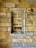 An intricate pattern of interlocking stone blocks in varying shades of beige, tan, and gray forms a textured wall. A recessed section, bordered by a stone frame, is seamlessly integrated into the stonework.