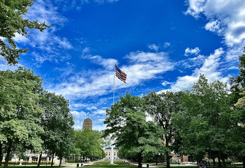 Una bandera estadounidense ondeando en el cielo sobre un parque