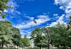 an american flag flying in the sky over a park