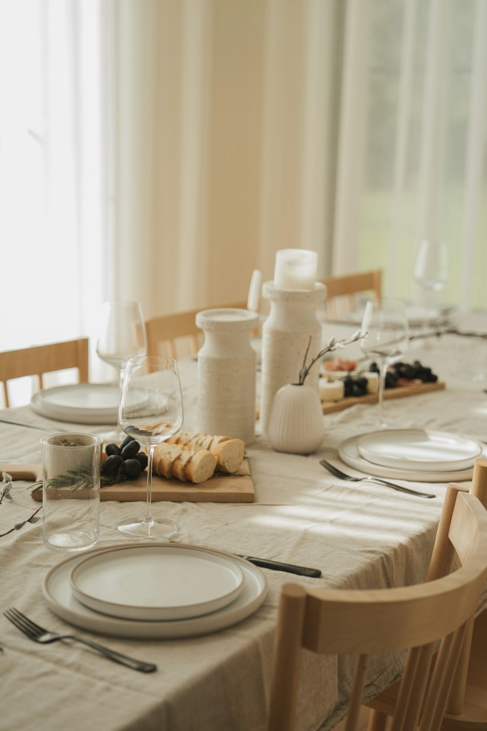 a table set for a formal dinner with wine glasses and plates