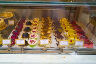 A selection of homemade desserts displayed in a glass case.