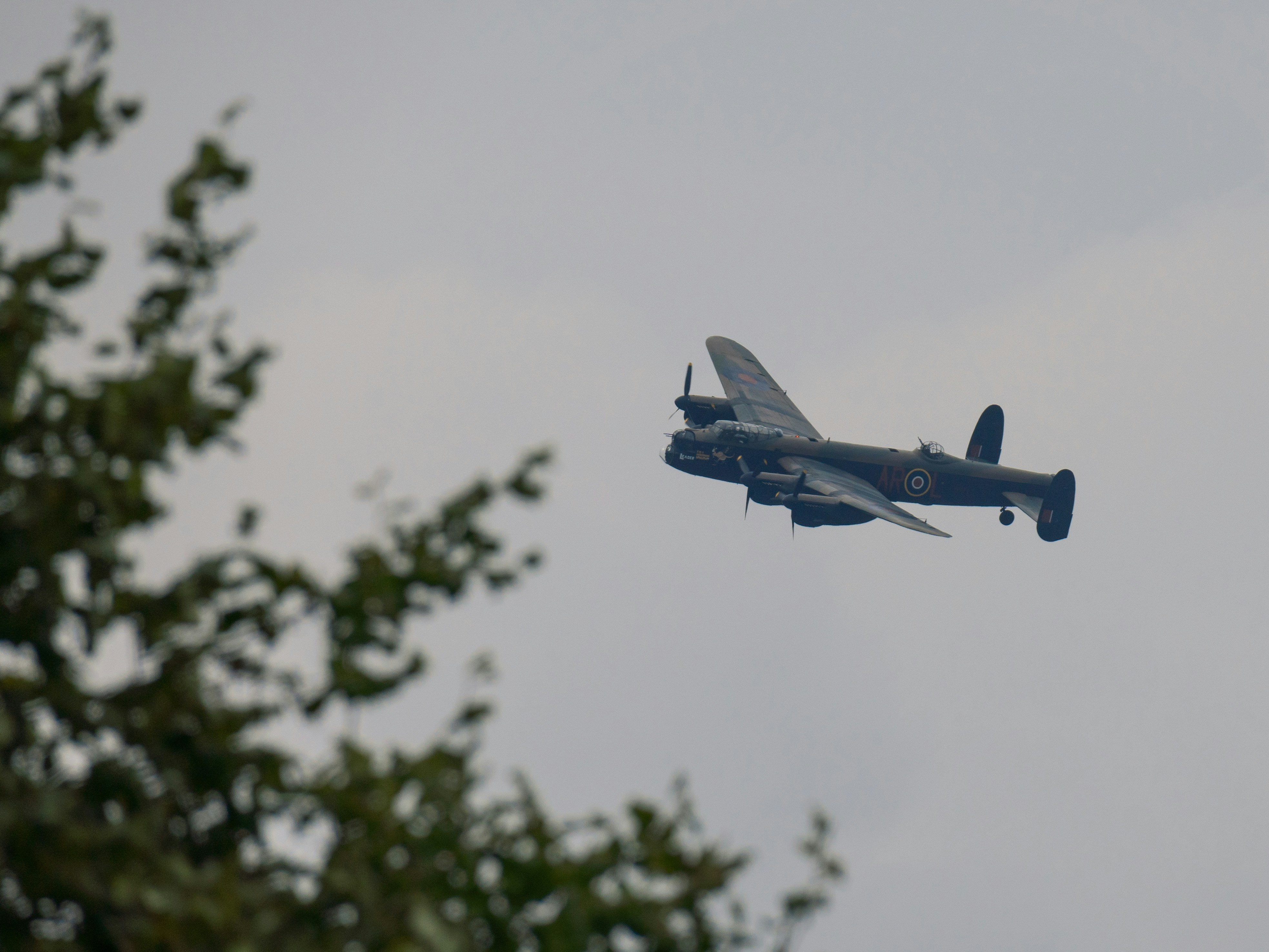 a small airplane flying through a cloudy sky, Avro Lancaster PA474 on a Battle of Britain memorial flight over Nottingham - 17th of September 2023.