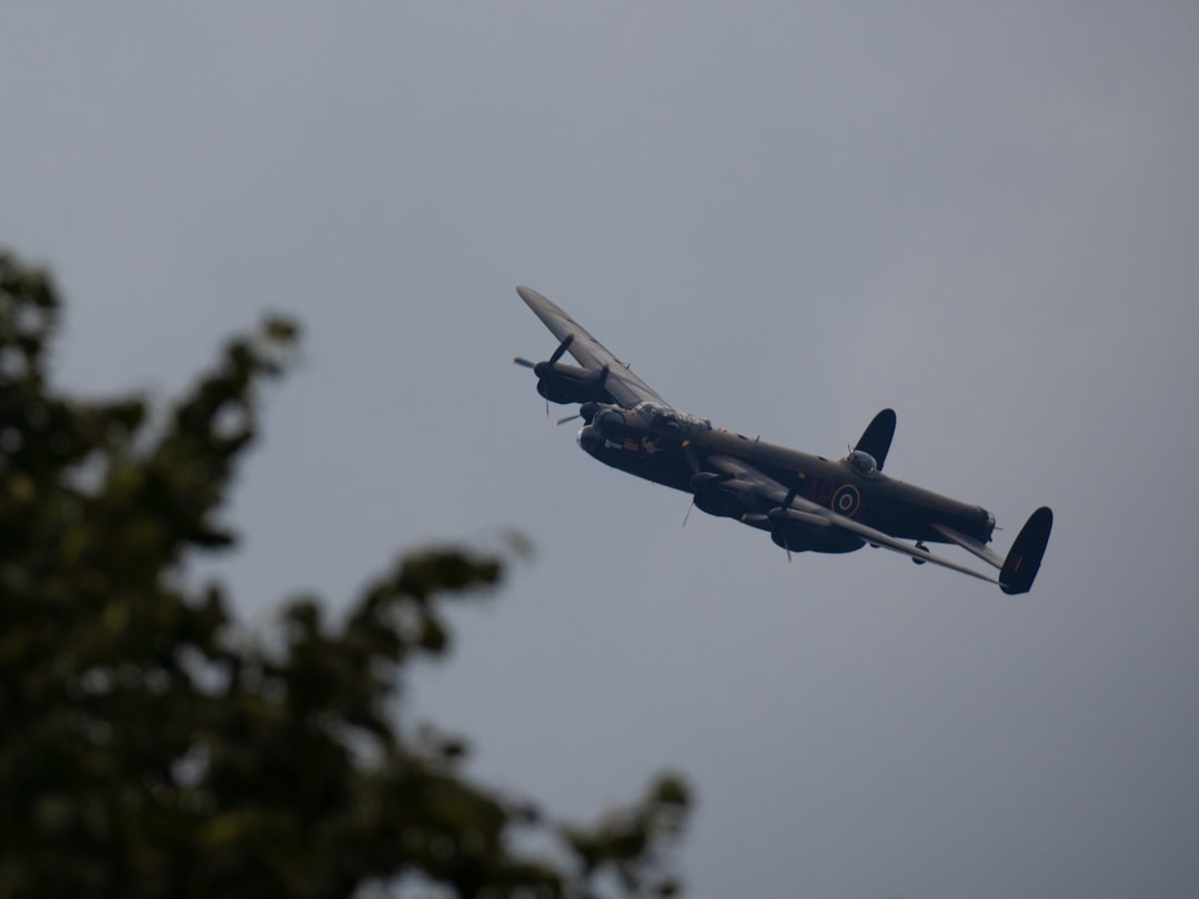 a plane flying in the air with trees in the background, Avro Lancaster PA474 on a Battle of Britain memorial flight over