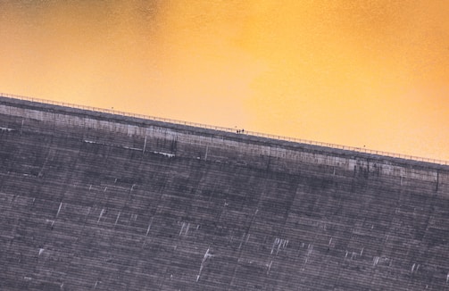 Time-lapse style image showing the progress of a large dam construction over several months.