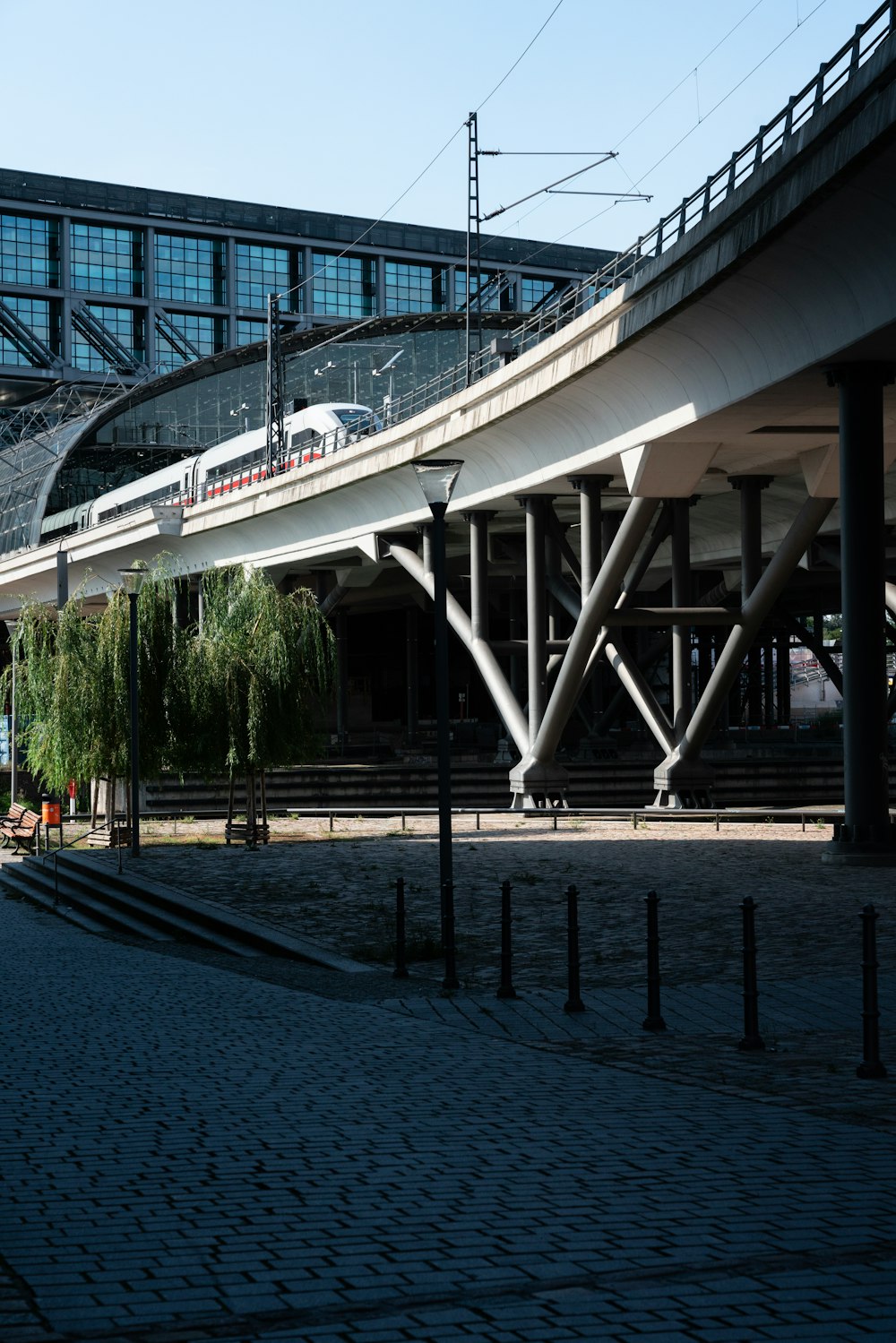 Ein Zug, der über eine Brücke neben einem hohen Gebäude fährt