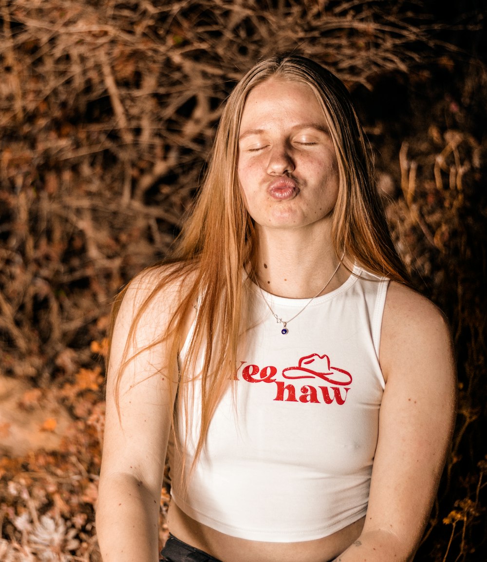 a woman with her eyes closed sitting in the grass