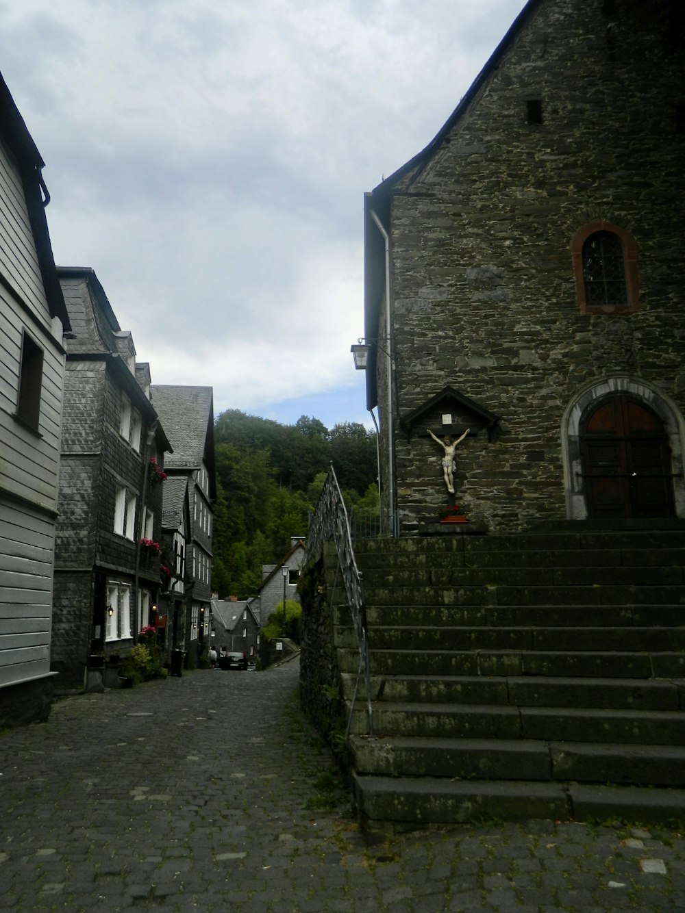 a cobblestone street with stone buildings and stairs