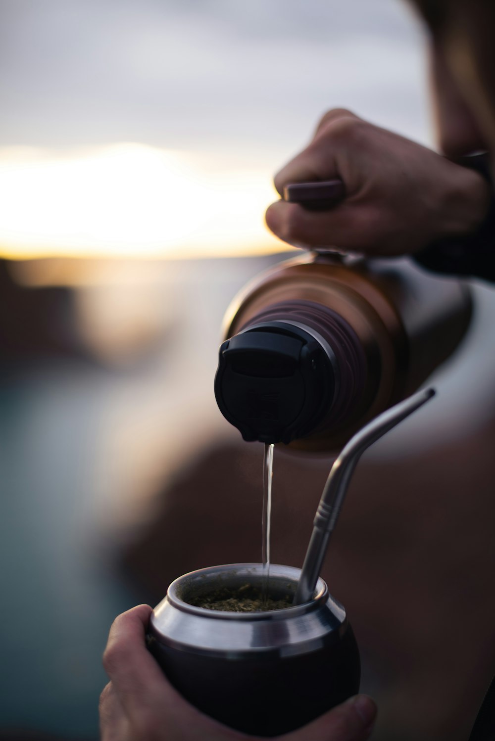 a person pouring coffee into a cup
