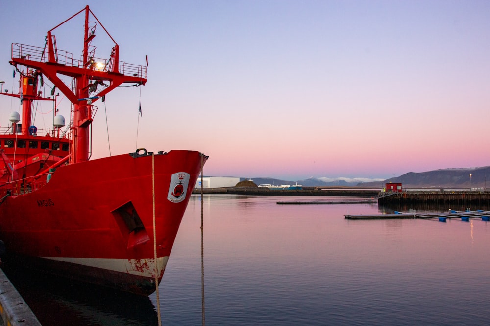 a large red boat docked at a dock