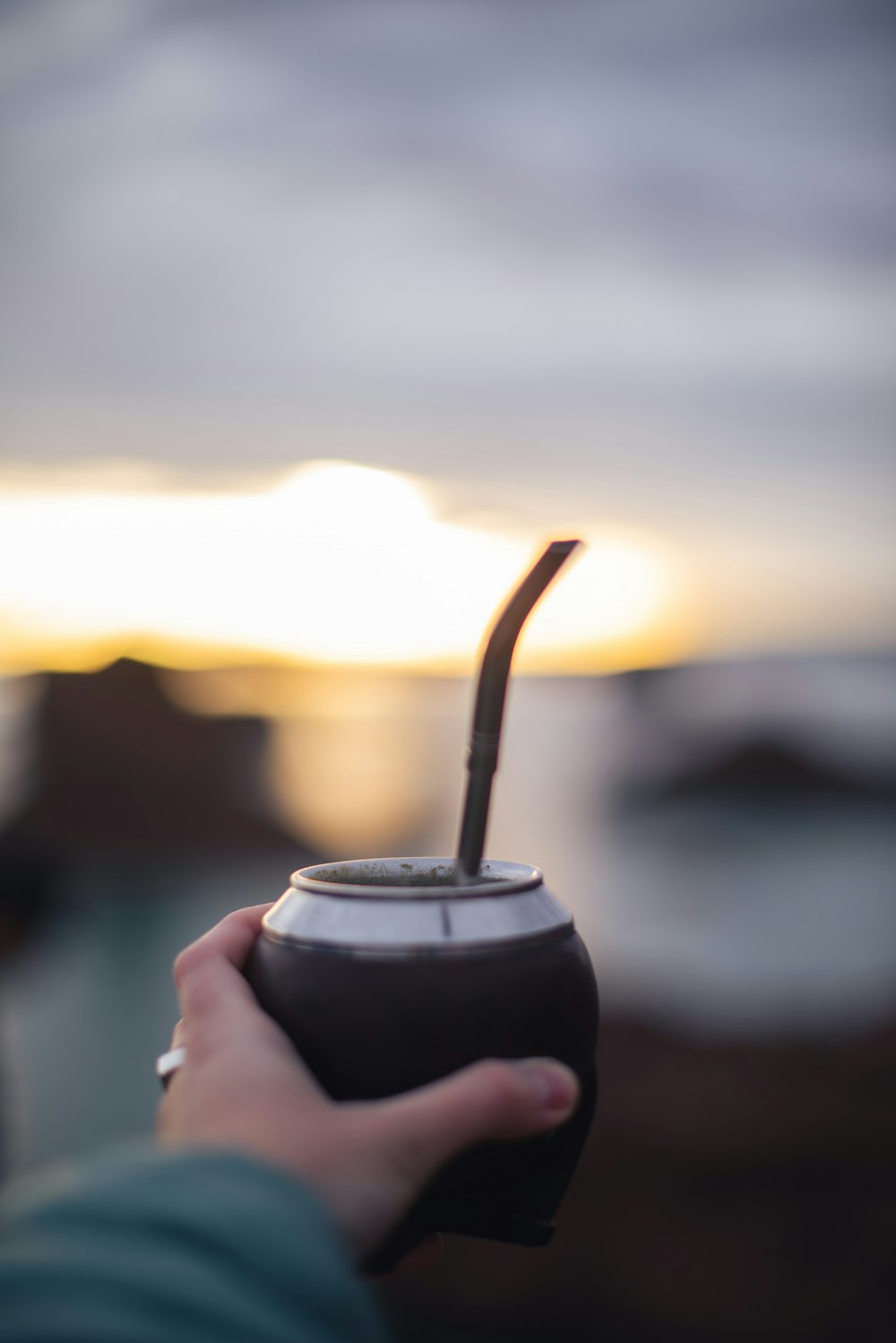 a person holding a cup with a straw in it