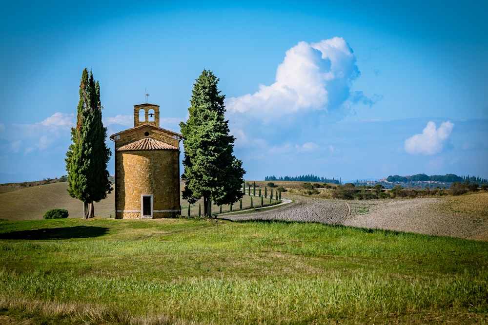 a small building in a field with trees around it