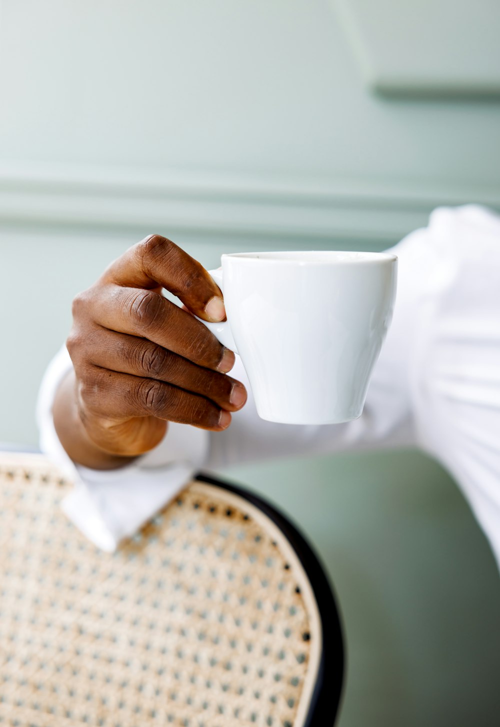 a close up of a person holding a cup