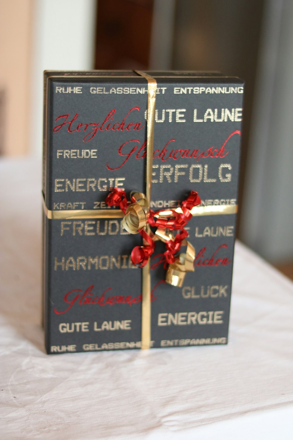 a gift wrapped in red and gold ribbon