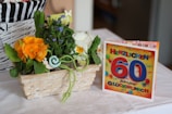 a basket of flowers next to a greeting card