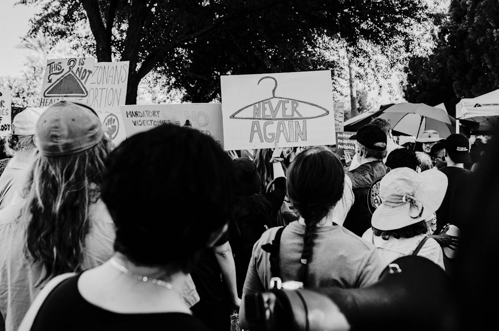 a group of people holding signs and umbrellas