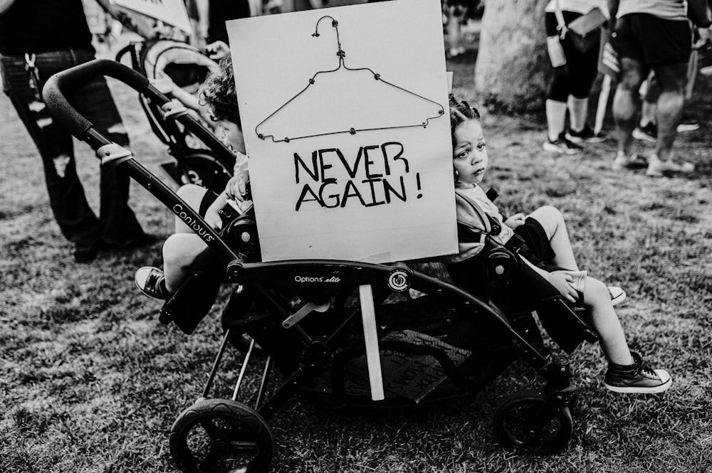 a sign on a stroller that says never again