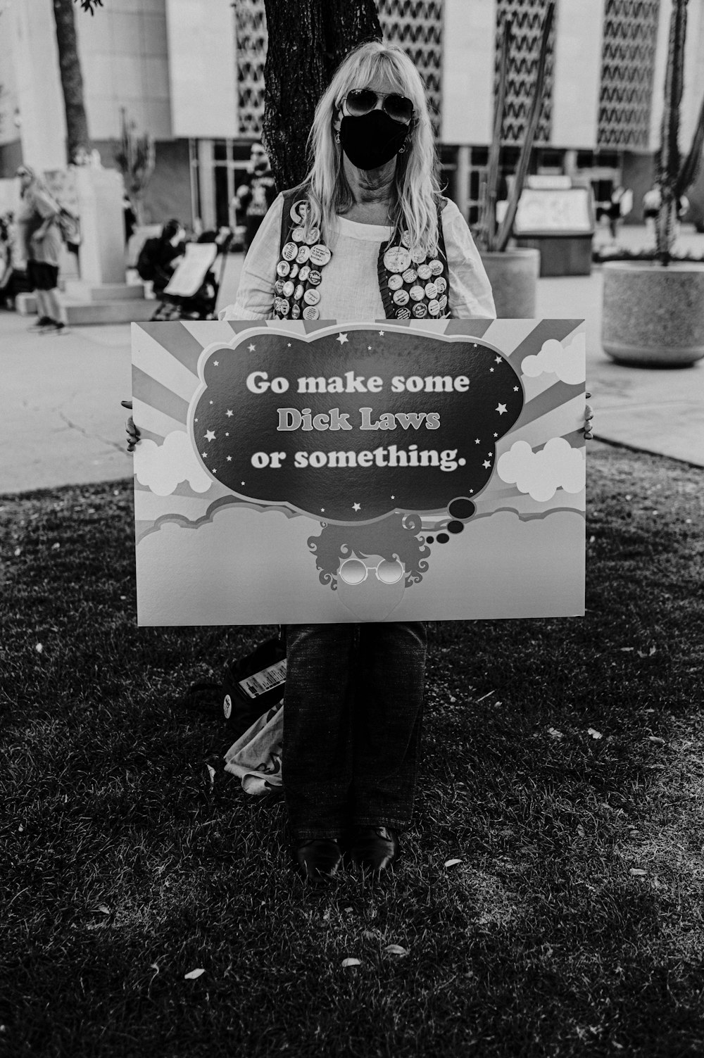 a woman holding a sign that says go make some dick leave or something