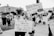 A black and white protest scene with individuals holding signs about women's rights. One sign reads, 'Girls should have control of their own bodies,' held by a young girl. Another sign says, 'Protect our daughters right of choice!' with a drawing of two stick figures.