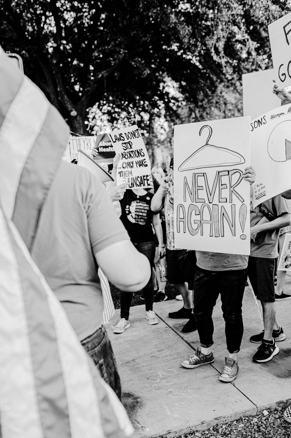 a group of people holding signs on a sidewalk