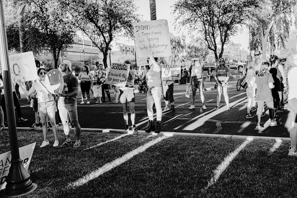 a group of people marching down a street holding signs