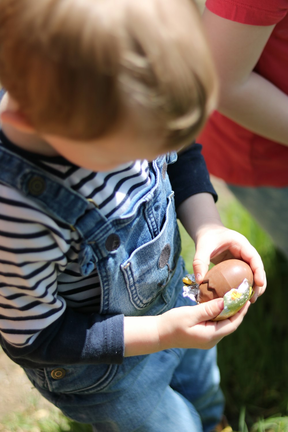 a young boy holding an egg in his hands