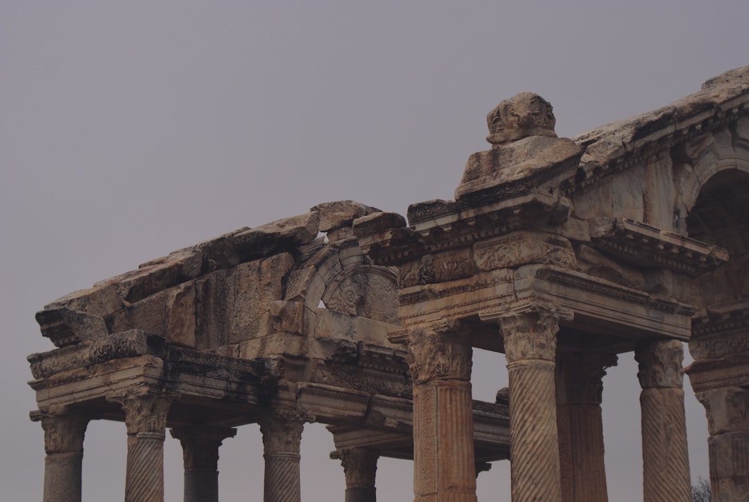 a group of stone pillars with a clock on each of them,