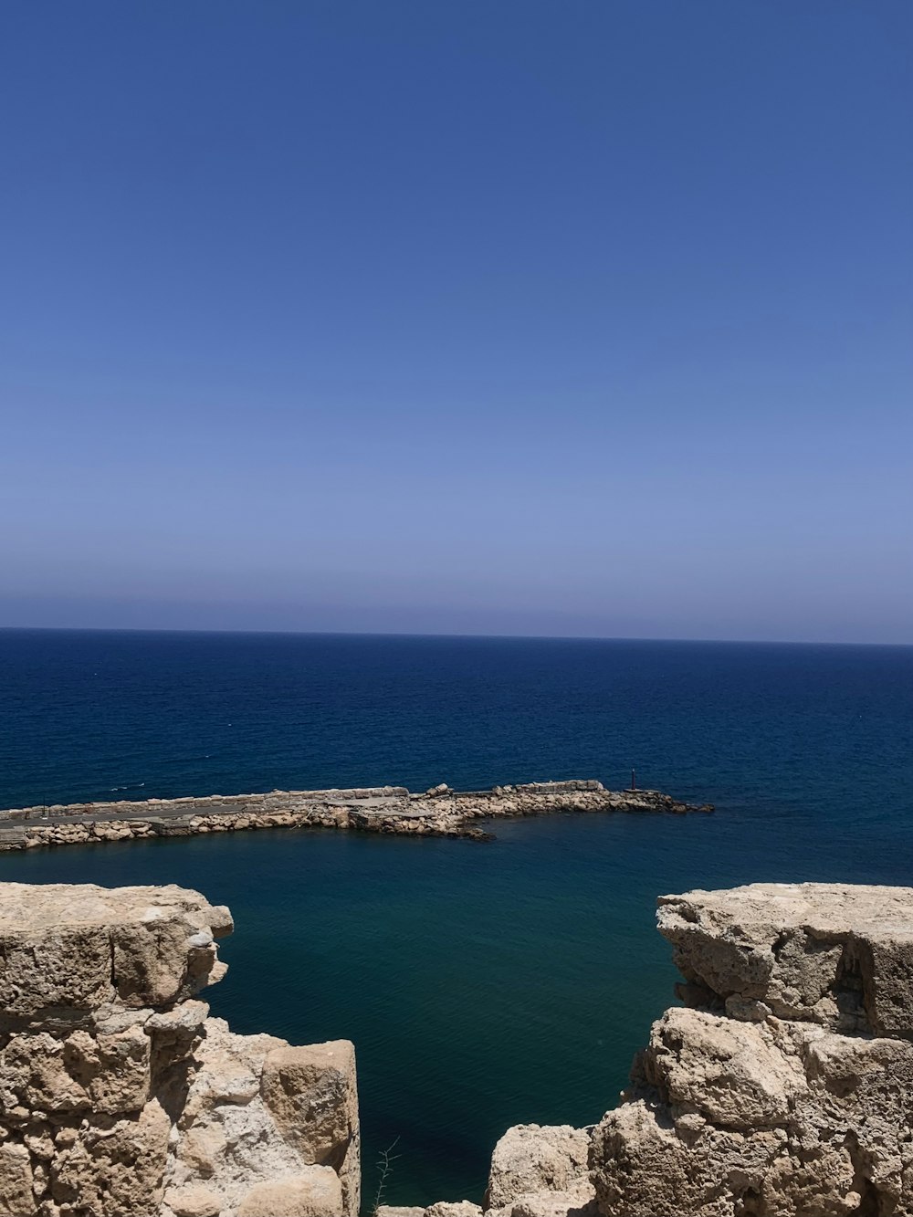 a large body of water sitting next to a rocky shore