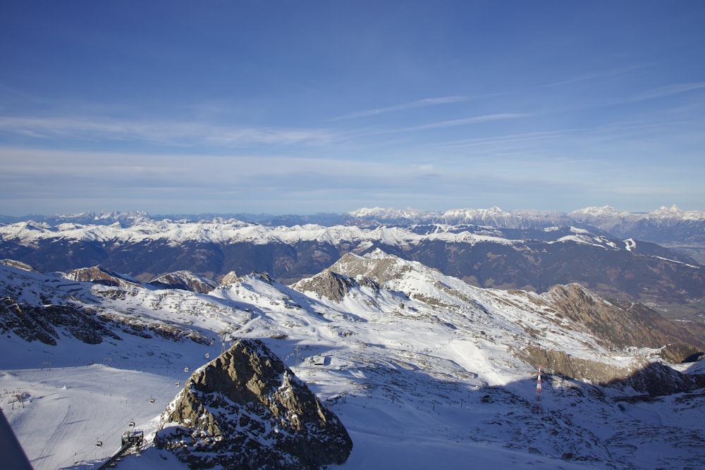 a view of a snowy mountain range from the top of a mountain