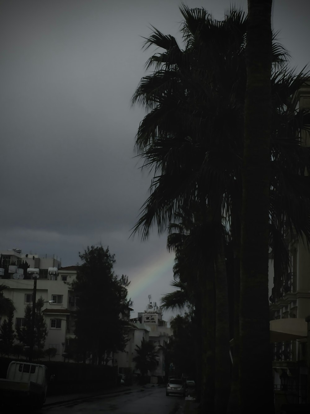 a rainbow in the sky over a city street