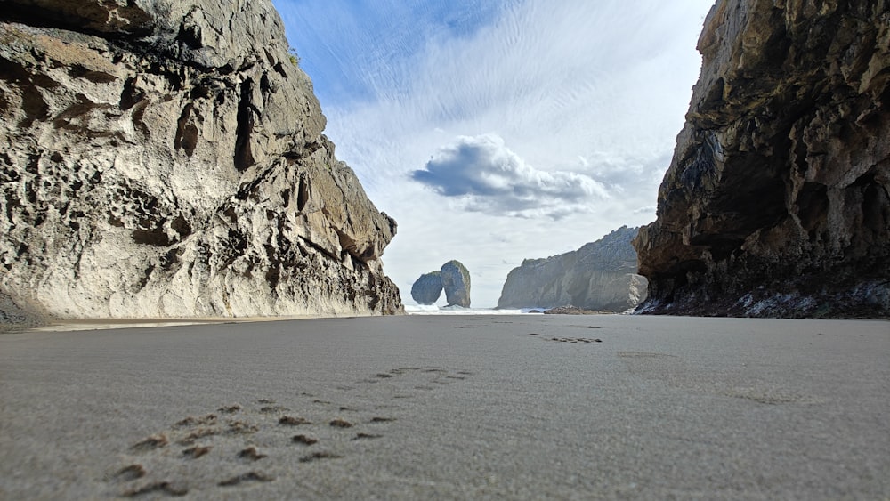 a view of a beach with a rock formation in the background