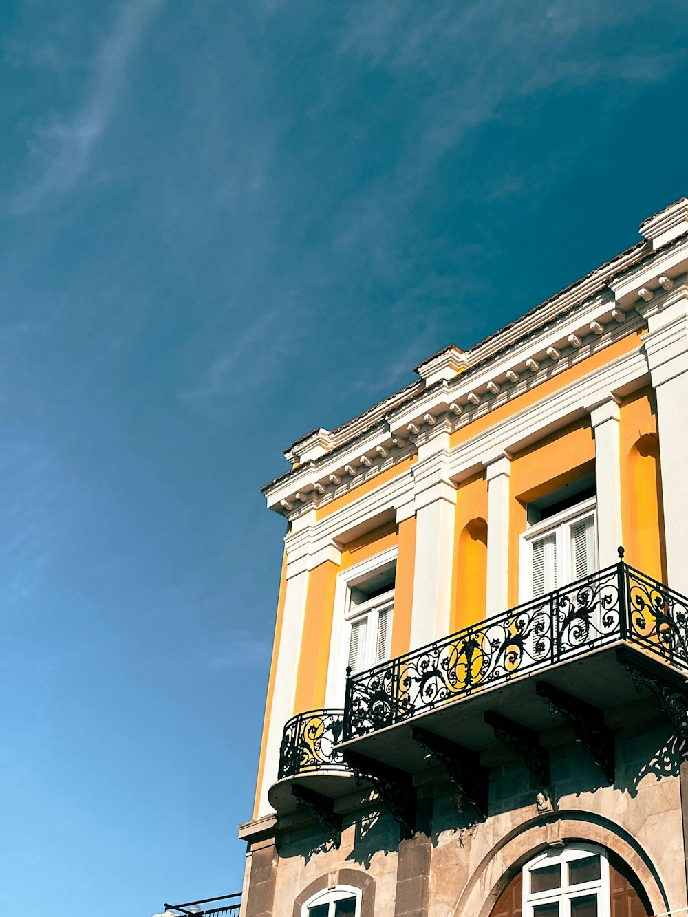 a yellow and white building with a balcony and balconies