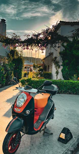 A bold electric scooter in vibrant orange parked on a busy Nairobi street at sunset.