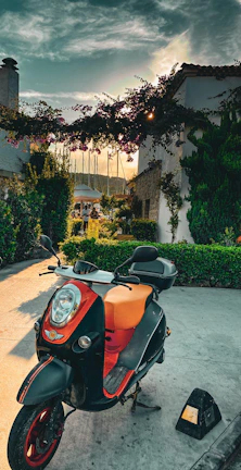 A stylish scooter parked near a vibrant Ibiza town square at sunset