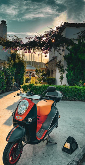 A vibrant scooter parked by a palm tree on a sunny Mauritius beach.