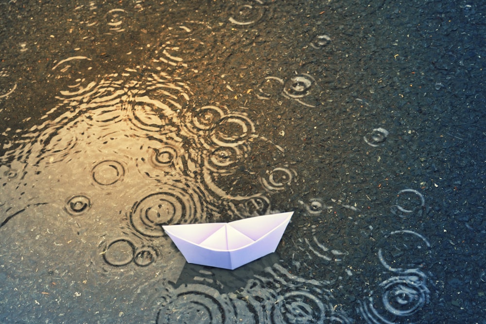 a white umbrella sitting on top of a wet ground
