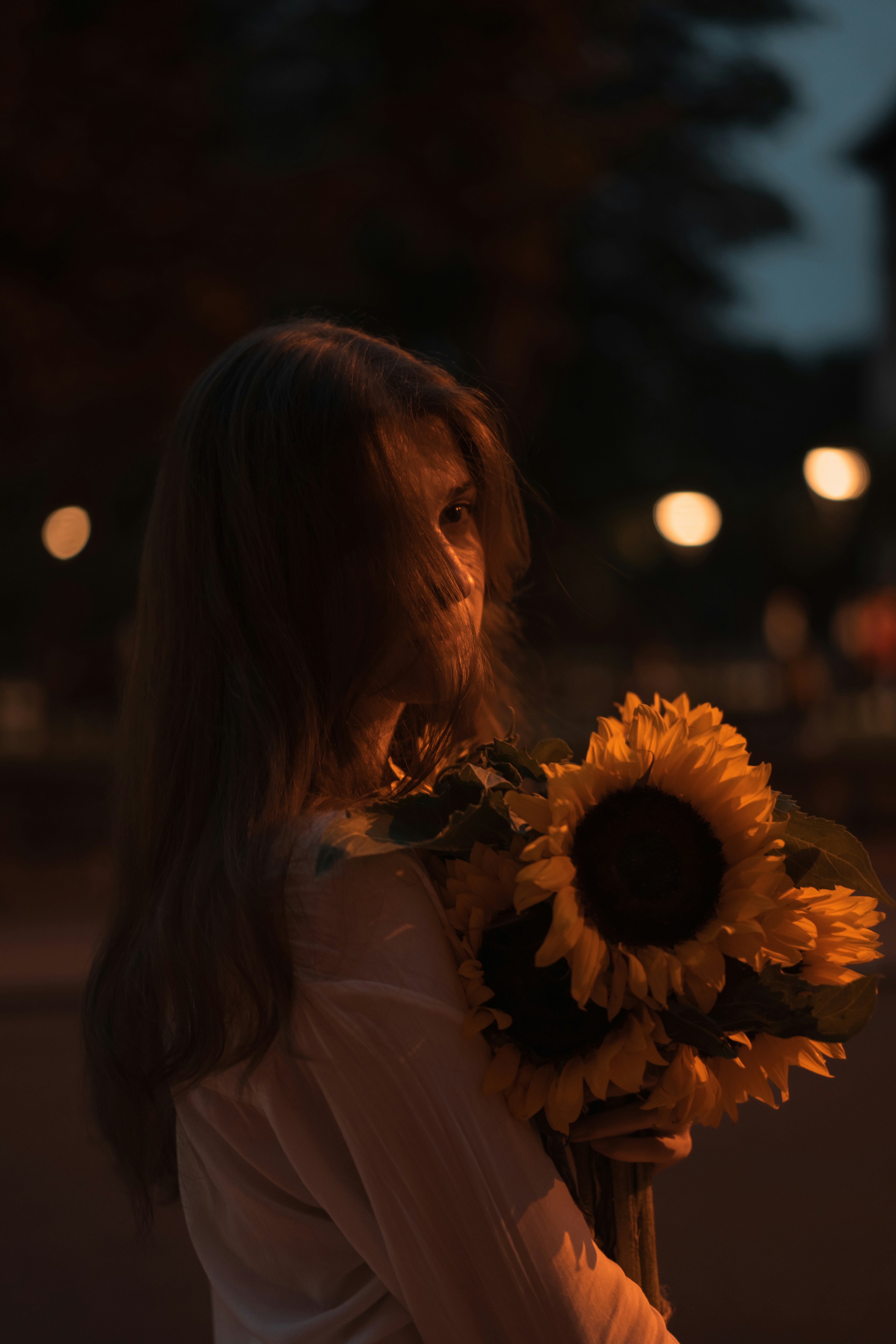 A woman holding a large sunflower in her right hand photo – Free Flower ...