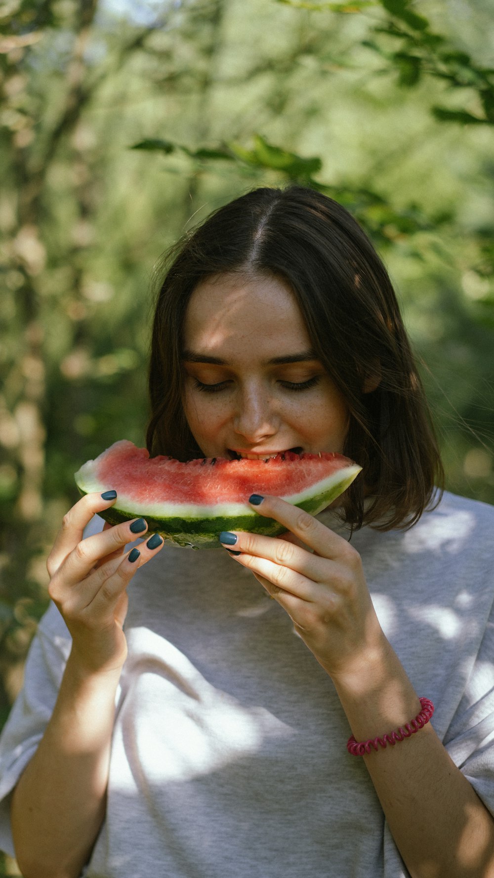 a woman is eating a piece of watermelon