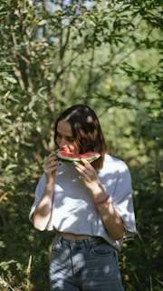 Happy customer enjoying a fruit roll outdoors surrounded by greenery.