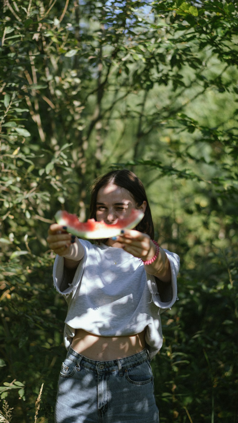 a woman holding a piece of watermelon in her hands