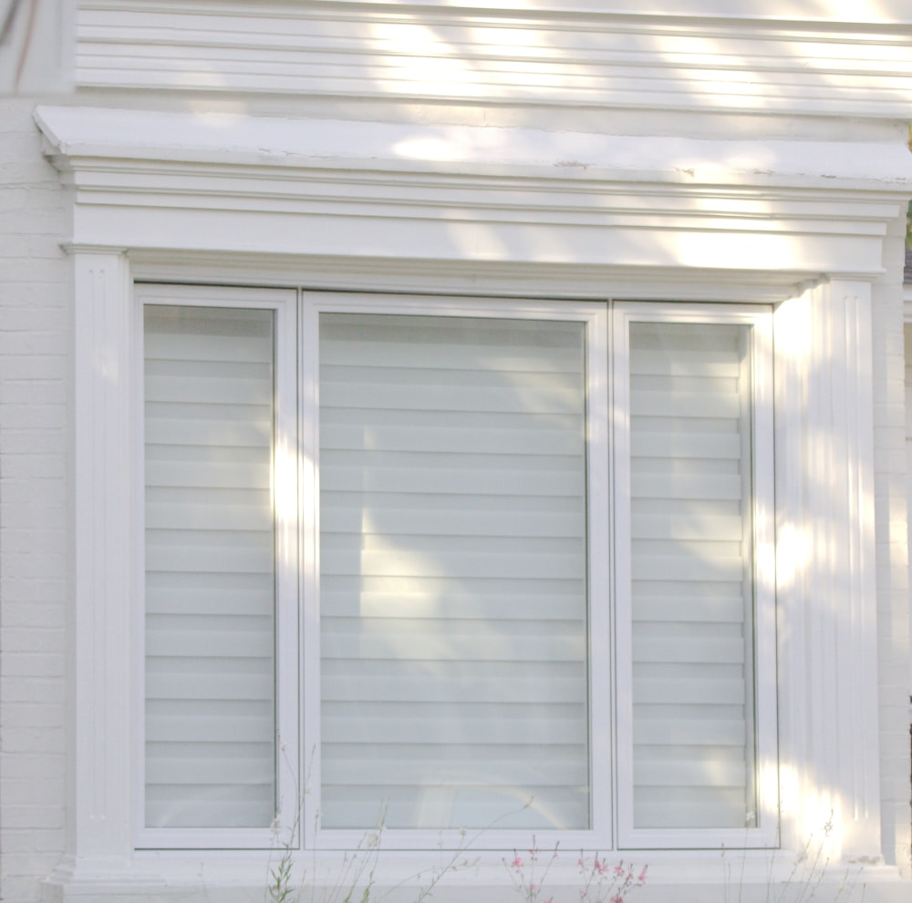 a cat sitting on a window sill in front of a house