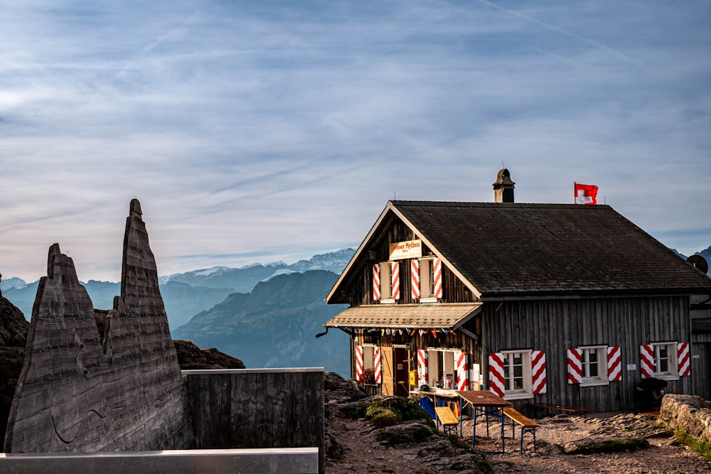 um pequeno edifício de madeira em um lado da montanha