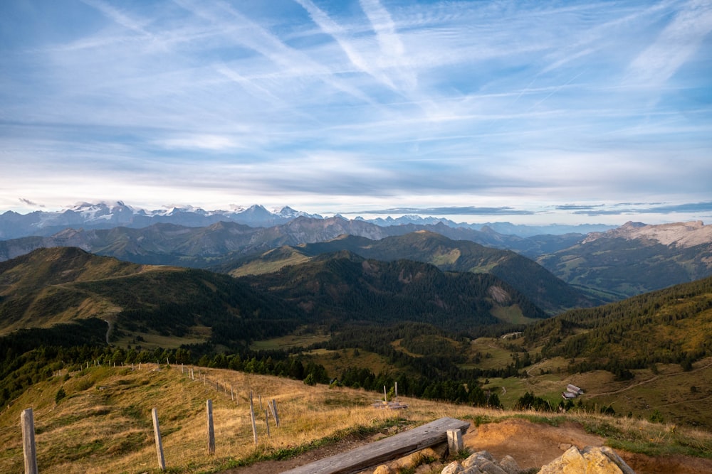 a bench on top of a mountain overlooking a valley