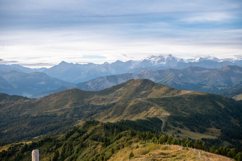 Una vista de una cadena montañosa con una valla en primer plano