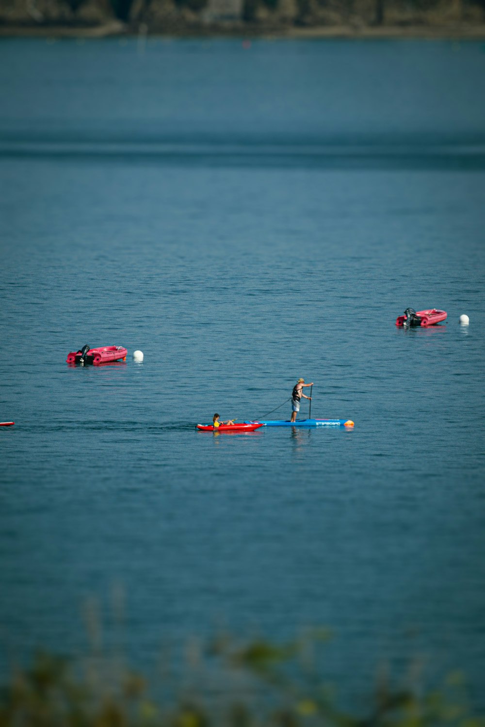 Un homme sur une planche à pagaie au milieu d’un lac