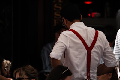 a man in a white shirt and red suspenders