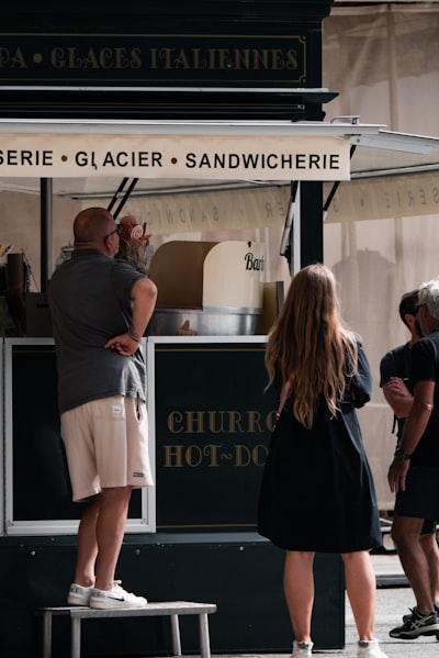 a group of people standing around a food stand