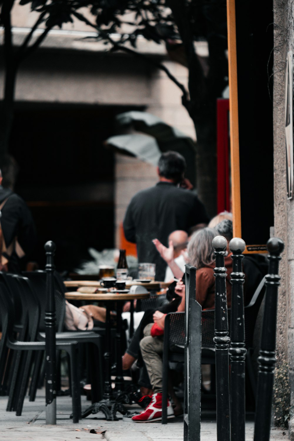 a group of people sitting at a table outside of a restaurant