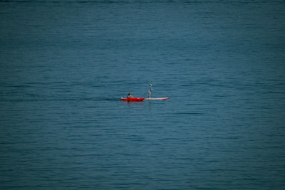 a person paddling a boat in the middle of the ocean