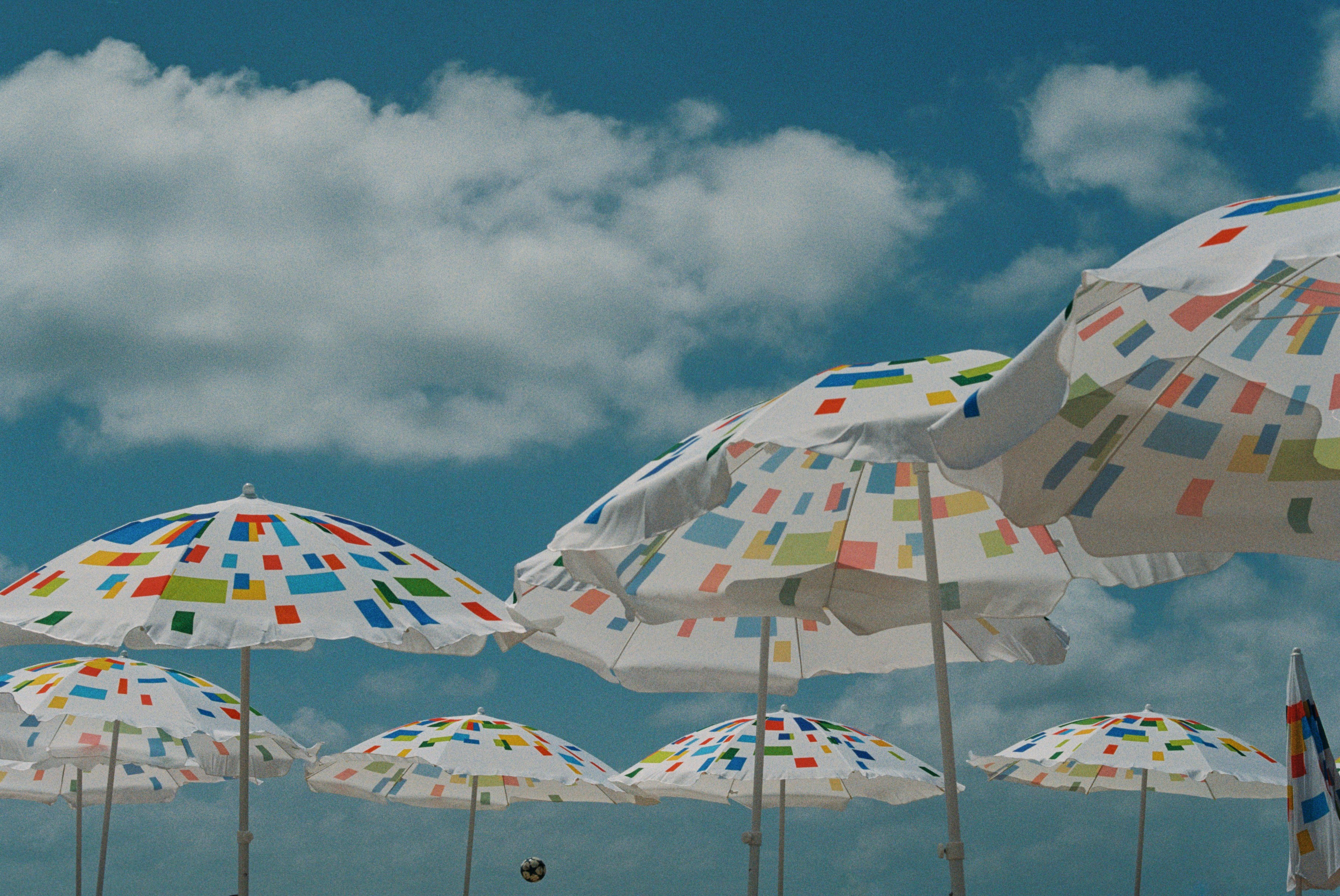 Polka-dot beach umbrellas under a blue sky