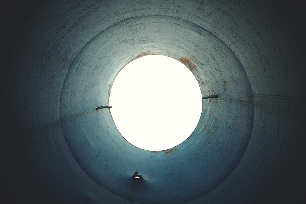 a round hole in a concrete structure with a light at the end